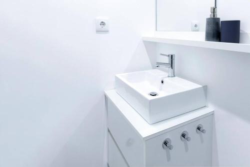 La salle de bains blanche est pourvue d'un lavabo et d'un comptoir. dans l'établissement Artury Porto, à Porto