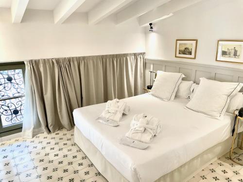a bedroom with two beds with towels on them at Hotel Basilica in Palma de Mallorca