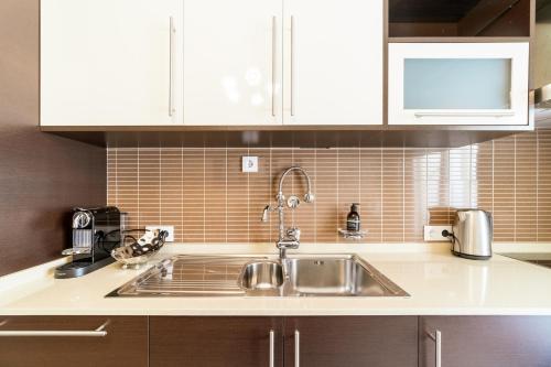 a kitchen with a sink and white cabinets at Histórical City Center Penthouse Albufeira in Albufeira