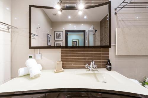 a bathroom with a sink and a large mirror at Histórical City Center Penthouse Albufeira in Albufeira
