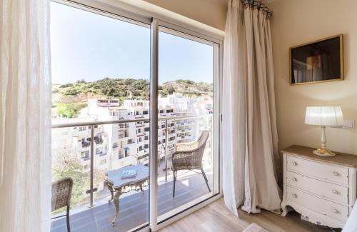 a bedroom with a large window with a view at Histórical City Center Penthouse Albufeira in Albufeira