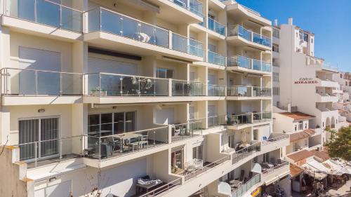 an apartment building with balconies and tables at Histórical City Center Penthouse Albufeira in Albufeira