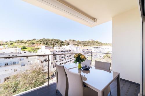 a dining room with a table and chairs and a large window at Histórical City Center Penthouse Albufeira in Albufeira