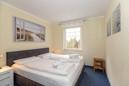 キュールングスボルンにあるHaus-Ostseewelle-Wohnung-19-413のベッドルーム(白いシーツを使用した大型ベッド1台付)