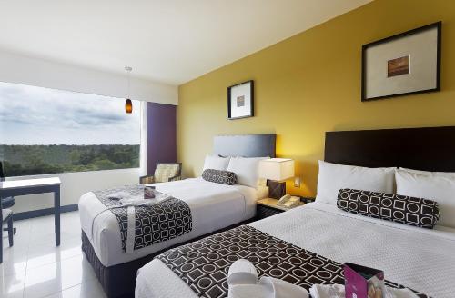 a hotel room with two beds and a balcony at Crowne Plaza Villahermosa, an IHG Hotel in Villahermosa