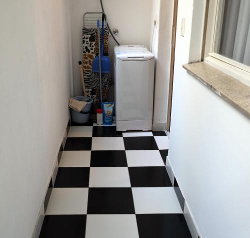 a black and white checkered floor in a hallway with a refrigerator at Administracion Callao in Buenos Aires