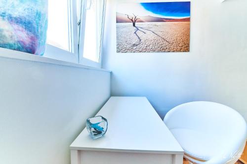 a room with a white stool and a picture on the wall at Automne in Brussels