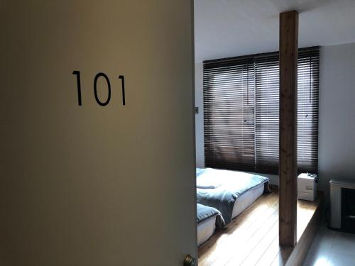 a bedroom with a bed and a window with the number at Sarabetsu-mura chiiki Kouryu Center - Vacation STAY 22064v in Sarabetsu