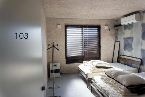 a bedroom with two beds and a window at Sarabetsu-mura chiiki Kouryu Center - Vacation STAY 25699v in Sarabetsu