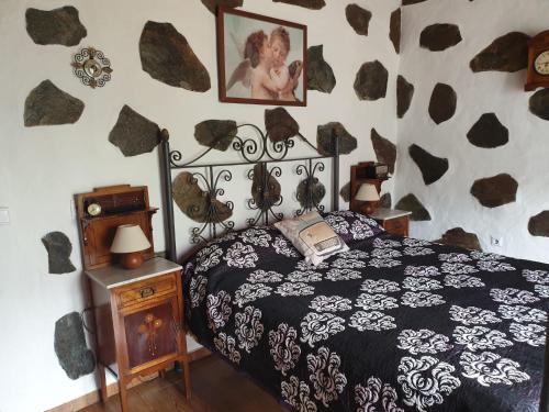 a bedroom with a bed with a black and white comforter at Casa Canaria Tejeda in Tejeda