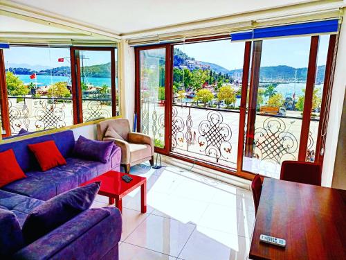 a living room with a purple couch and large windows at Mermaid suite in Fethiye