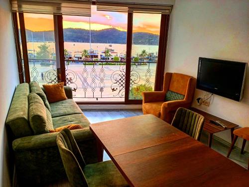 a living room with a couch and a table and a television at Mermaid suite in Fethiye