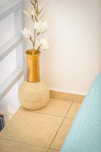 a vase with white flowers in it sitting on a counter at DS Traditional Villas Santorini Island in Karterados