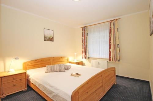 キュールングスボルンにあるHaus-Ostseewelle-Wohnung-5-411のベッドルーム1室(木製ベッド1台、窓付)