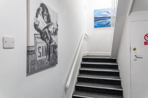 a hallway with stairs and posters on the wall at Darlington Town Centre Apartments free parking and Wi-Fi in Darlington