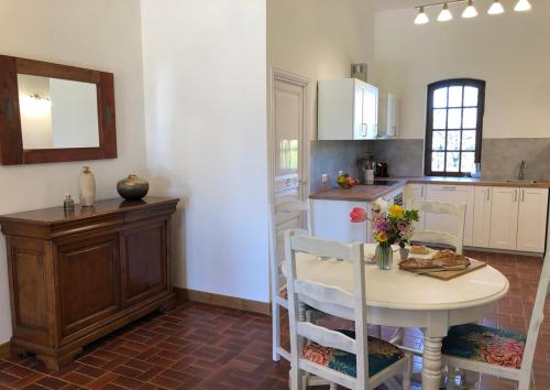 a kitchen with a table and a table and chairs at Malepère in La Bastide-de-Bousignac