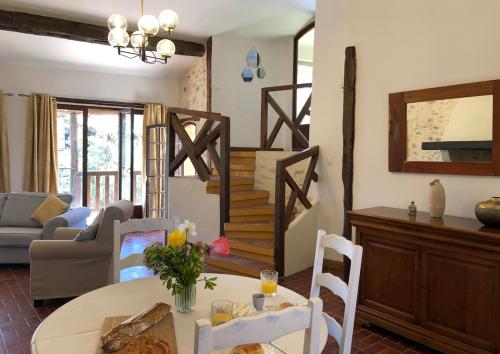 a living room with a table and a staircase at Malepère in La Bastide-de-Bousignac