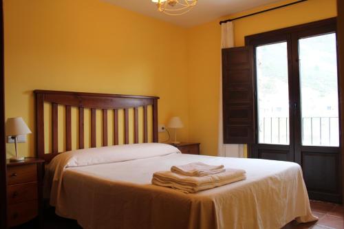 a bedroom with a bed with towels on it at Apartamentos NOGUERA de ALBARRACÍN in Noguera de Albarracin