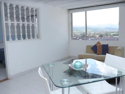 a living room with a glass table and a couch at Hotel Don Gregorio in Cartago