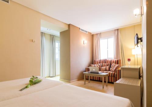 Habitación de hotel con cama y sofá en Hotel Platería, en Écija