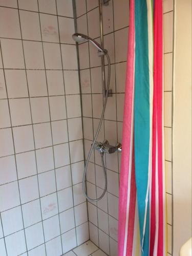 a shower in a bathroom with colorful towels at Fru Hald in Løkken