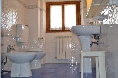 a white bathroom with a sink and a toilet at Fattoria di Belvedere in Poppi