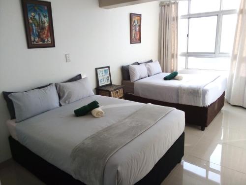 a bedroom with two beds and a couch at Sandz accomodation at 108 in Durban
