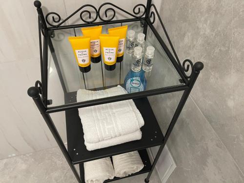 szklaną półkę w łazience z ręcznikami i szczoteczkami do zębów w obiekcie Jolie Luxury Apartments II w mieście Timişoara