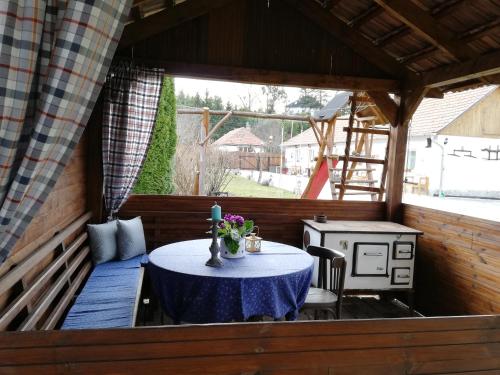 a porch with a table and a stove in it at Bóbita Apartmanház in Szilvásvárad