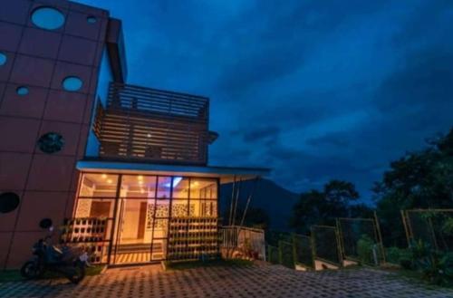 a building with a balcony on top of it at night at Palmtree Leaf, Munnar in Munnar