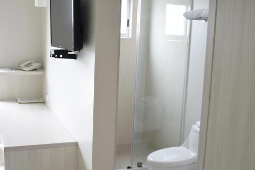 a bathroom with a shower and a toilet and a television at SC HOTEL in Xalapa