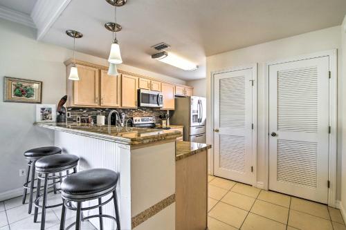 a kitchen with a counter and stools in it at South Padre Island Condo with Pool Access and Balcony! in South Padre Island