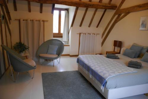 a bedroom with a bed and chairs in a room at Odiel & Gabrielle in Montchevrier