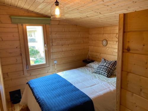 ein Schlafzimmer mit einem Bett in einer Holzhütte in der Unterkunft Apartamento Rural La Casita de Mateo in Rascafría