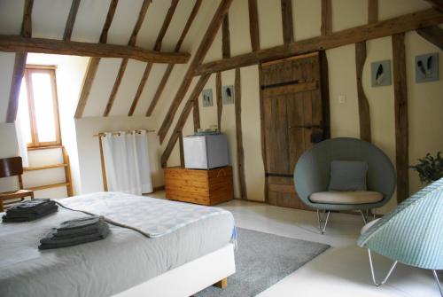 a bedroom with a bed and a chair at Odiel & Gabrielle in Montchevrier