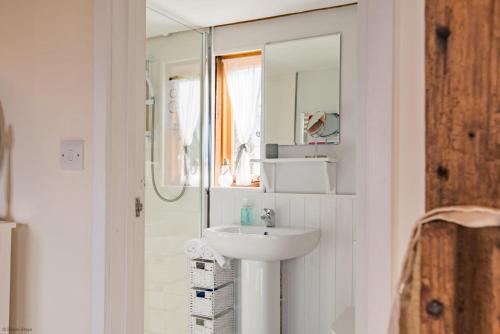 a white bathroom with a sink and a mirror at The Granary by Bloom Stays in Canterbury