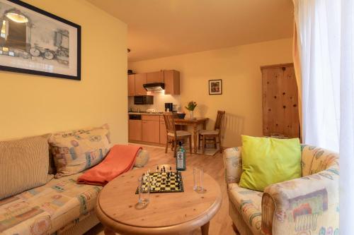 ein Wohnzimmer mit einem Sofa und einem Schachbrett auf einem Tisch in der Unterkunft Ferienwohnung #20 Am Neuensiener See - Seedorf in Sellin