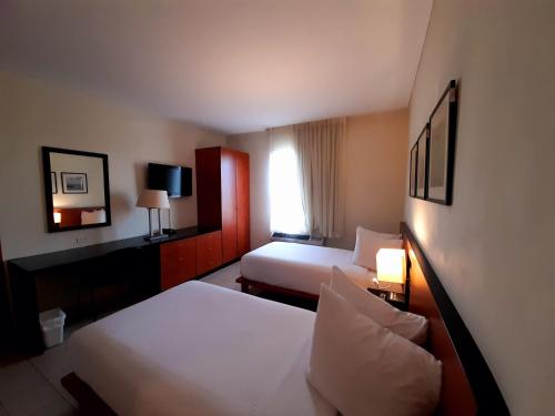 ein Hotelzimmer mit 2 Betten und einem Fenster in der Unterkunft Comfort Inn Real La Union in La Unión