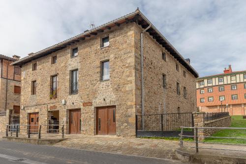 a large brick building with brown doors on a street at Burruzkale Etxea in Orozko