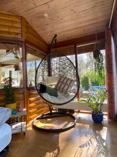 a room with a hanging chair in a house at Chalet de kleine Eekhoorn in Lage Mierde