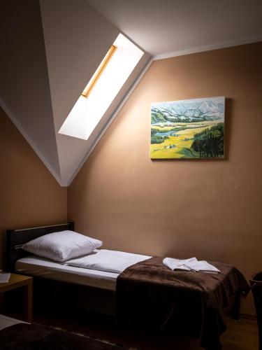 a bedroom with a bed and a skylight at Park UNESCO Residence in Łęknica