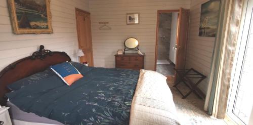 a bedroom with a bed with a blue comforter at Nuthatch Lodge in King's Lynn