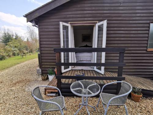 a house with chairs and a table and a window at Nuthatch Lodge in King's Lynn