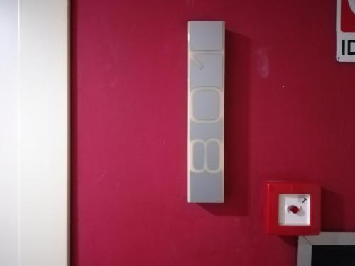 un mando a distancia blanco en una pared roja en Glass House intero appartamento centro città, en Cosenza