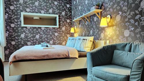 a bedroom with a bed and a chair and a mirror at Penzion Bílá voda in Harrachov