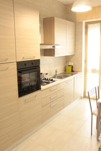 a kitchen with wooden cabinets and a stove top oven at Alcalù in San Vincenzo