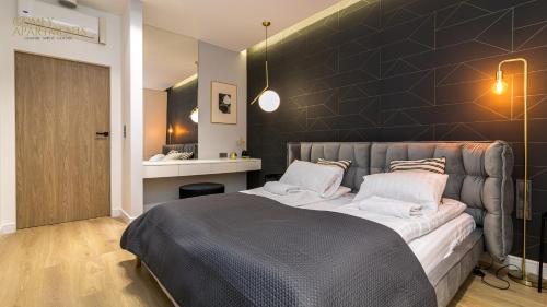 ein Schlafzimmer mit einem großen Bett und einer schwarzen Wand in der Unterkunft Apartament Chmielny River View - Granaria - Comfy Apartments in Danzig