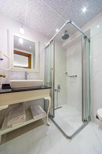 a white bathroom with a sink and a shower at Hotel Spectra Sultanahmet in Istanbul
