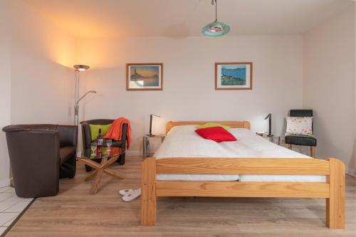 sypialnia z drewnianym łóżkiem i krzesłem w obiekcie Ferienwohnung #3 Am Neuensiener See - Seedorf w mieście Sellin