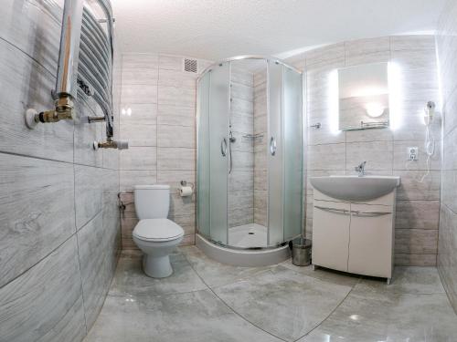 a bathroom with a shower and a toilet and a sink at Park UNESCO Residence in Łęknica